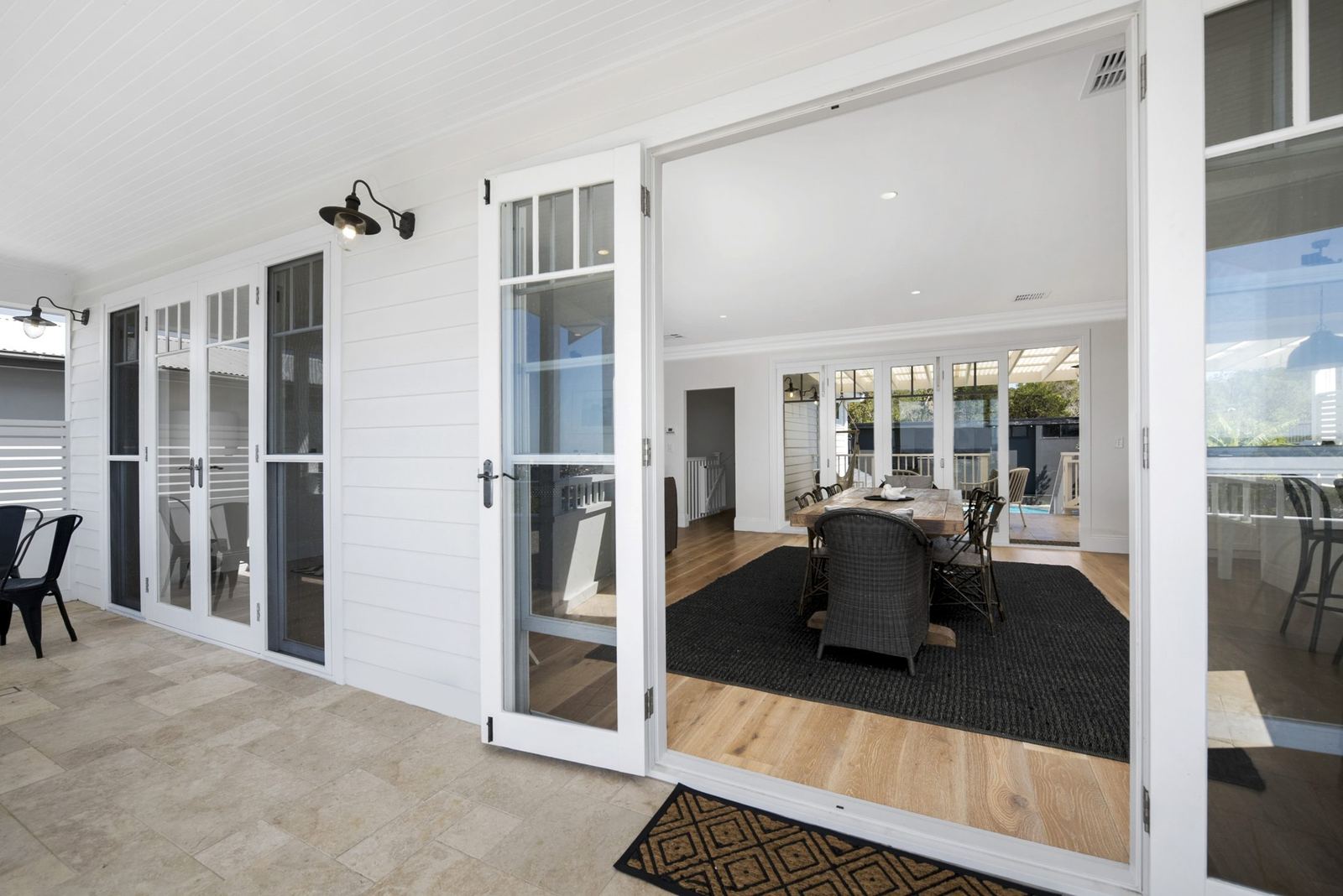 Balgowlah Heights, covered veranda with white doors and travertine floor to outdoor dining, built by HP Constructions with All Australian Architecture