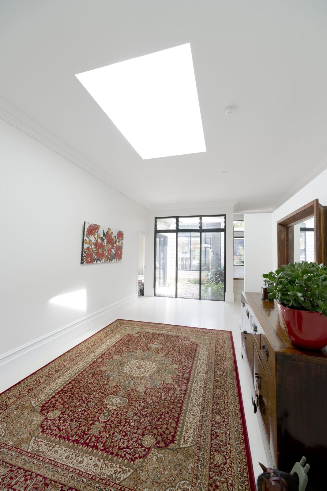 Balgowlah, living space with raked ceiling, skylight, timber floor and patterned rug, built by HP Constructions with Scope Architects
