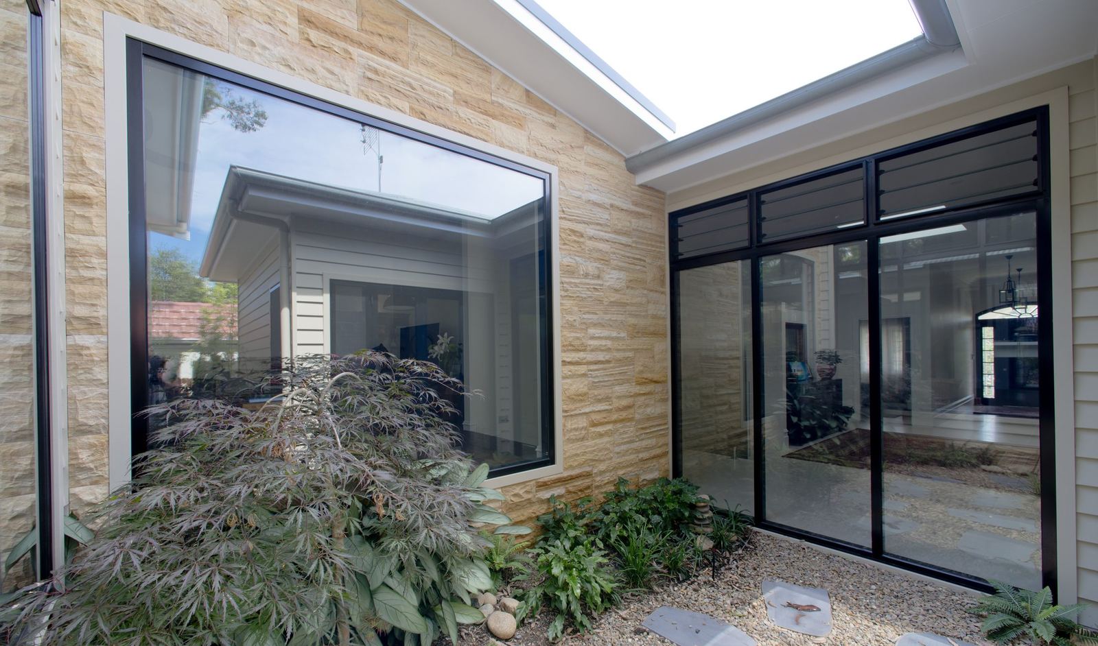 Balgowlah, sandstone-walled atrium courtyard with picture window, skylight and Japanese maple, built by HP Constructions with Scope Architects