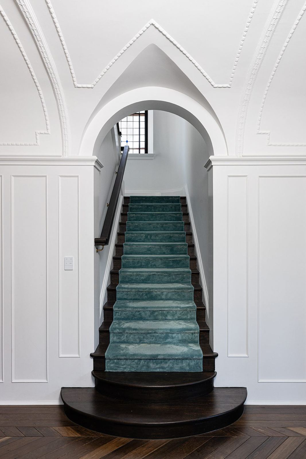 Bellevue Hill, curved timber staircase in a white arched stairwell with teal carpet, built by HP Constructions with Foster & Associates