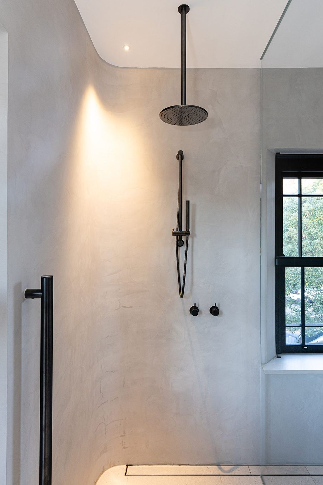 Bellevue Hill, microcement bathroom with black rain shower head and framed window, built by HP Constructions with Foster & Associates