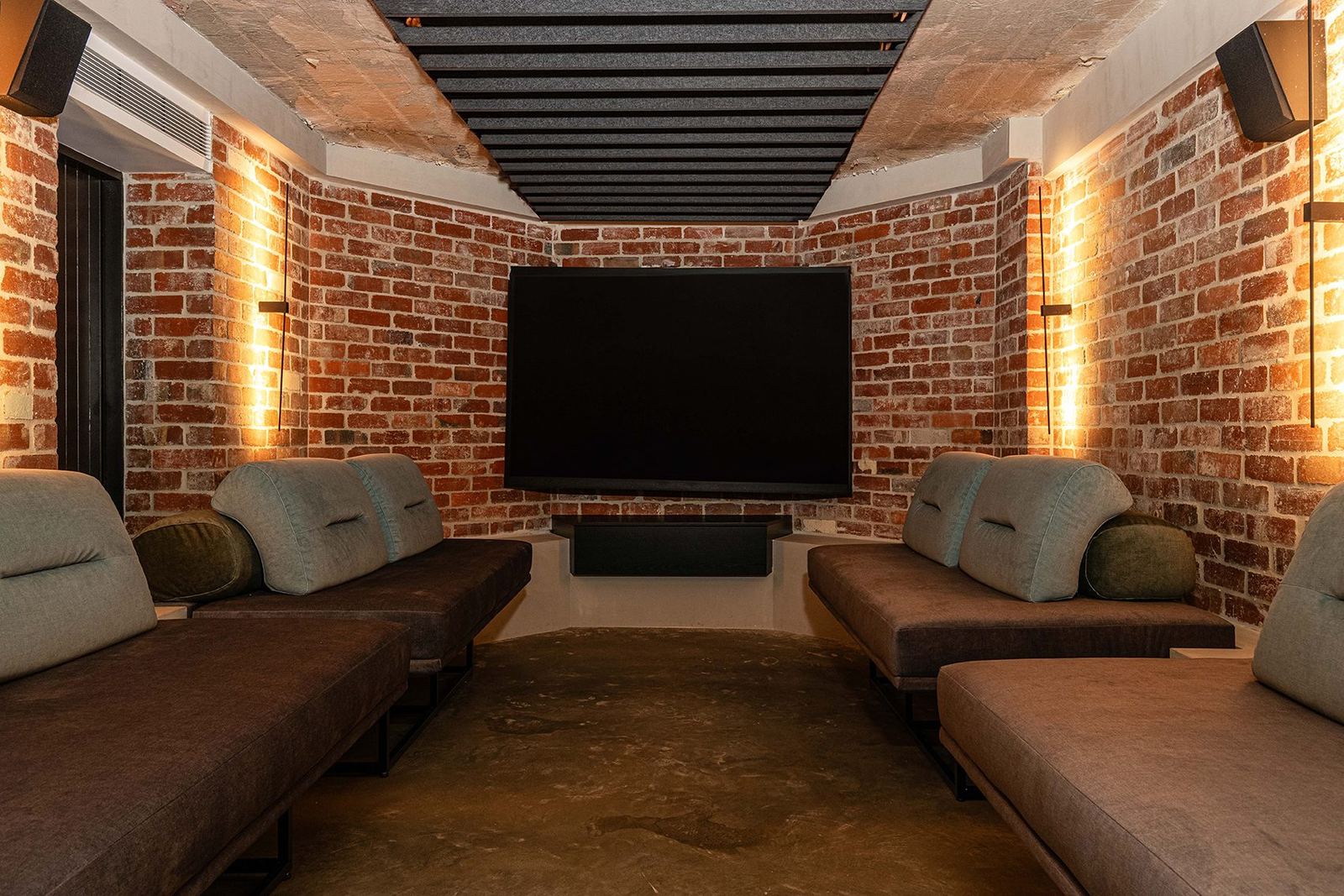 Bellevue Hill, brick-walled cinema room with black-beamed ceiling, wall TV and chaise lounges, built by HP Constructions with Foster & Associates