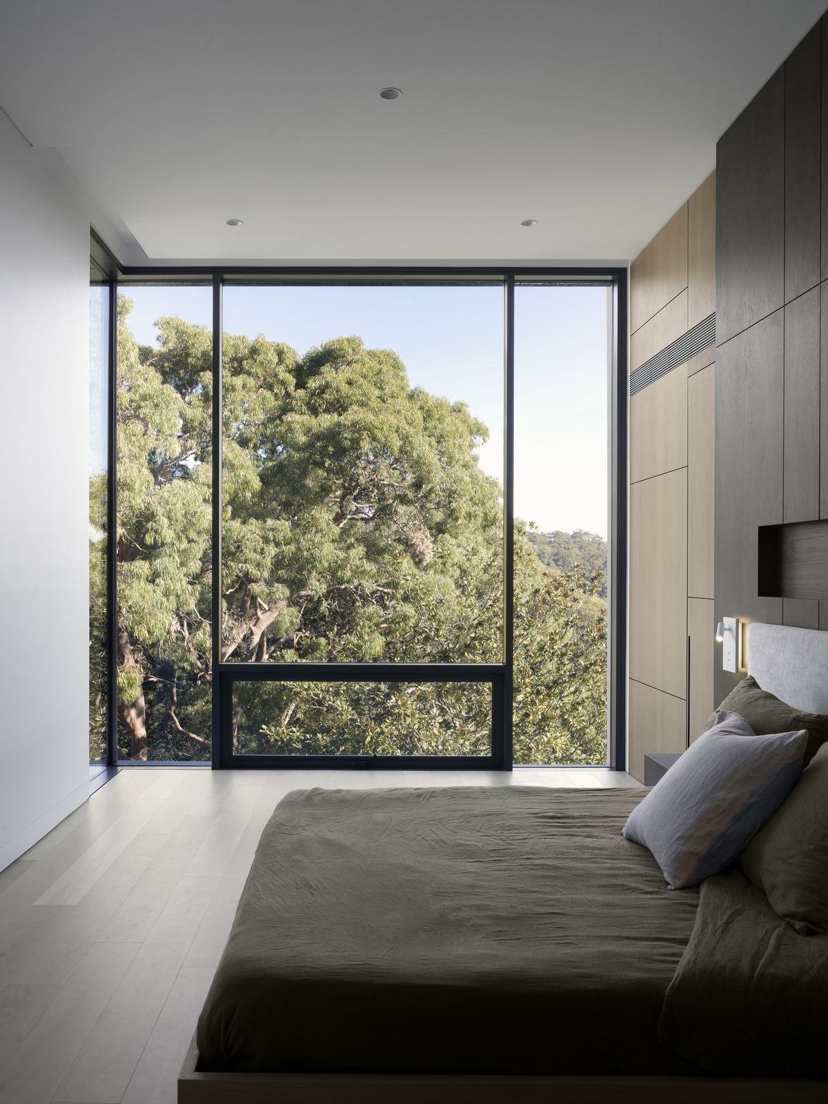 Castle Cove, bedroom with corner glazing framing treetop views, built by HP Constructions with Dieppe Design