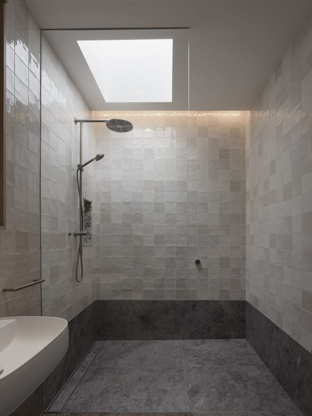 Castlecrag, stone-tiled shower room with skylight and built-in bench, built by HP Constructions with FJC Studio