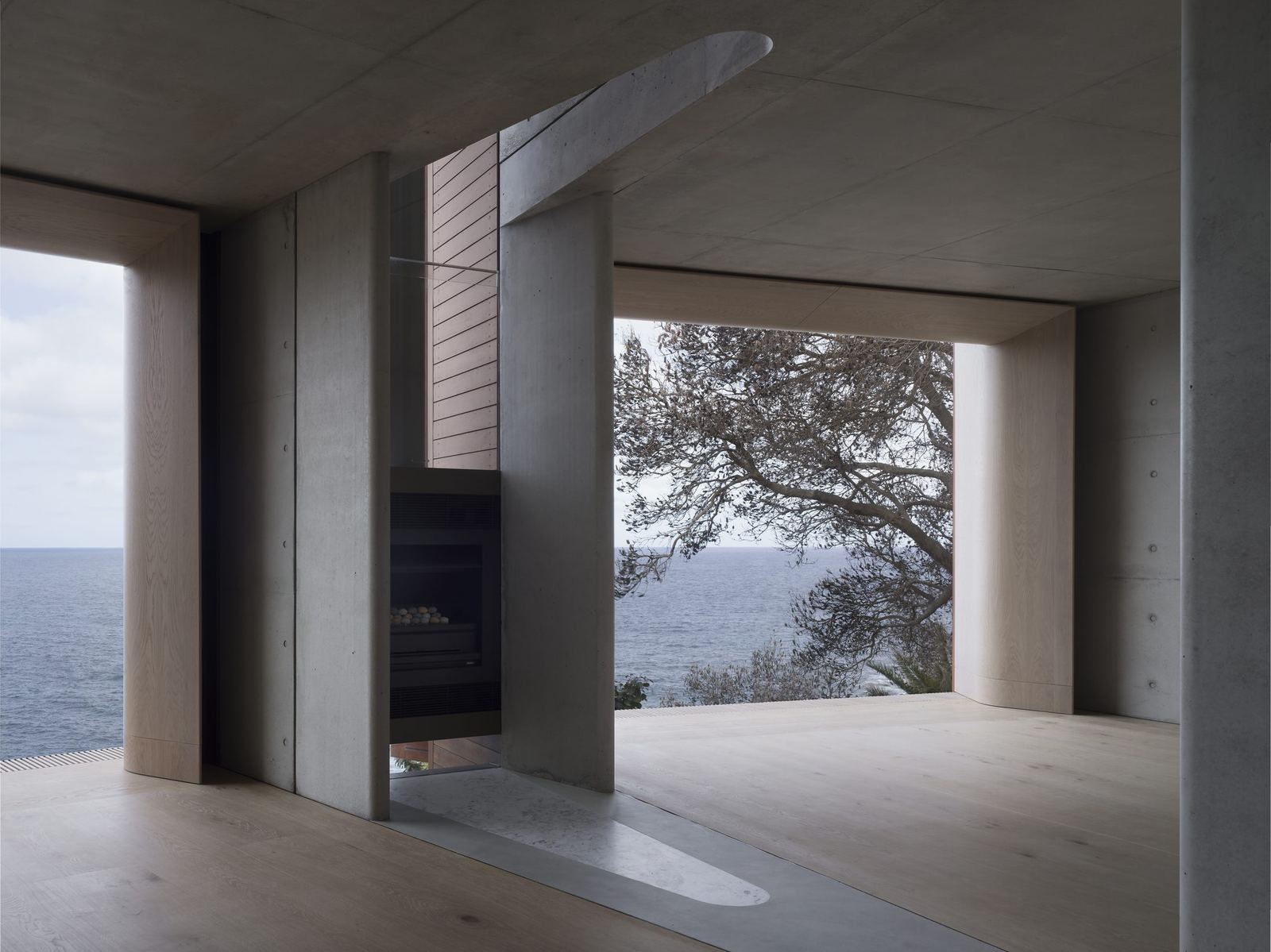 Lurline Bay, living room with fireplace and expansive coastal views, built by HP Constructions with FJC Studio