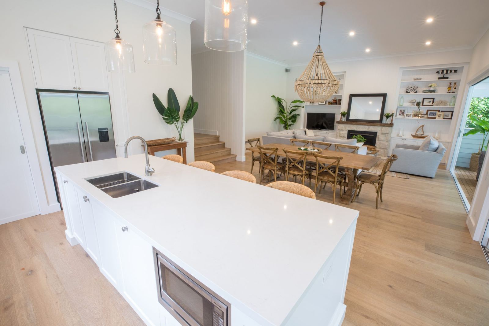 North Balgowlah, kitchen with white waterfall island, staircase and chandelier, built by HP Constructions with J.D Evans & Co