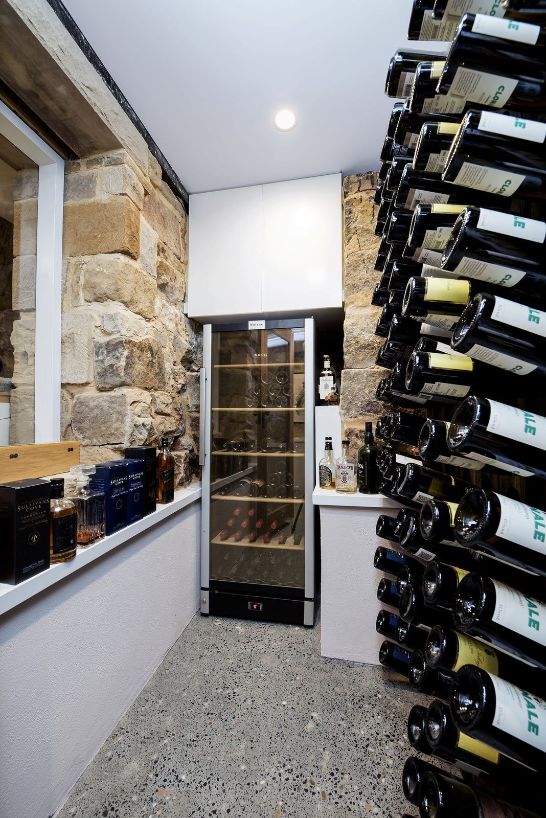 Paddington, wine cellar with wall-mounted racks and exposed sandstone wall, built by HP Constructions with Gutnik Design Group