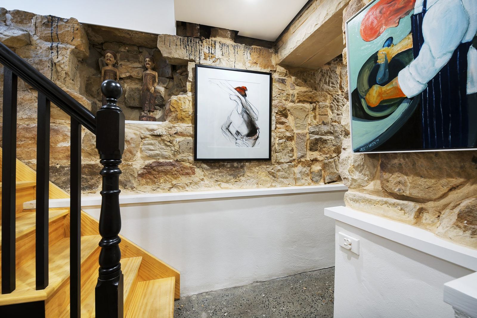 Paddington, staircase with black balustrade, exposed sandstone wall and artwork, built by HP Constructions with Gutnik Design Group