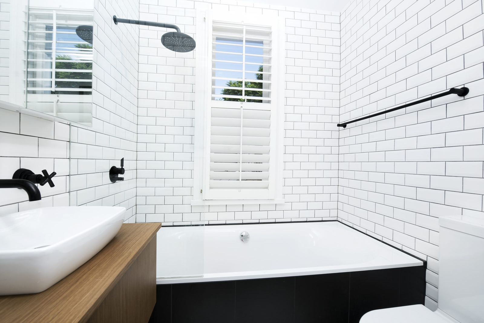 Paddington, bathroom with white subway tiles, black tapware and timber-clad bath, built by HP Constructions with Gutnik Design Group