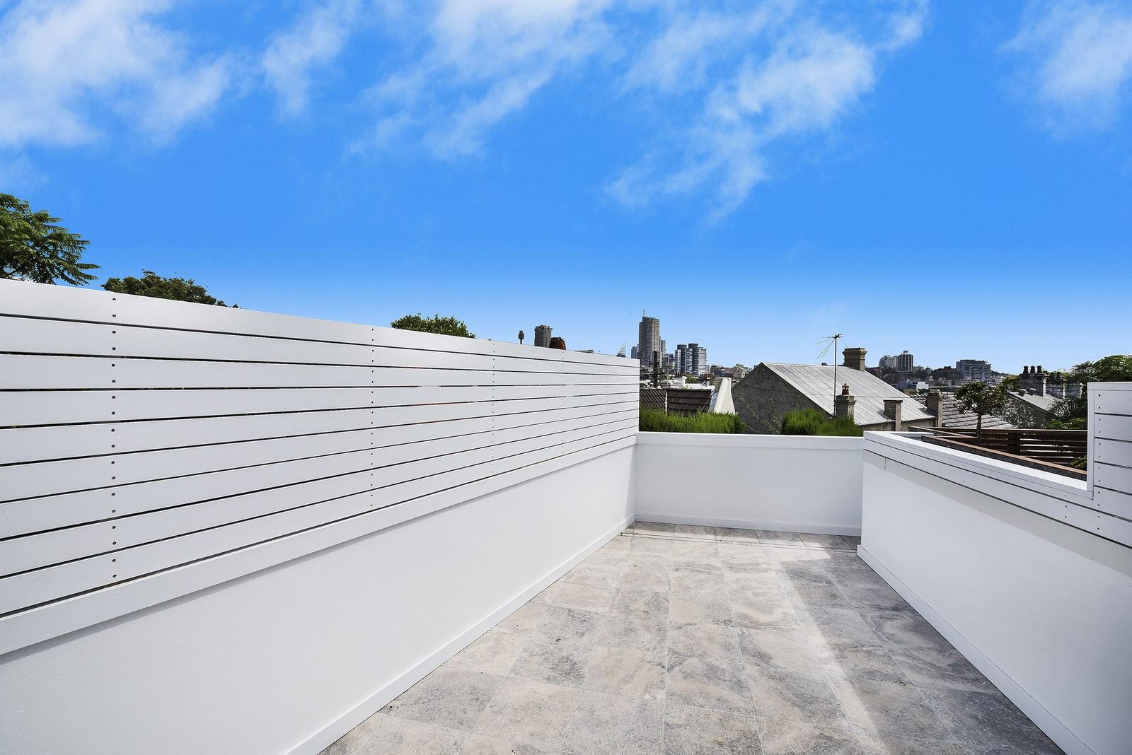 Paddington, rooftop terrace with white slatted screen and distant city skyline, built by HP Constructions with Gutnik Design Group