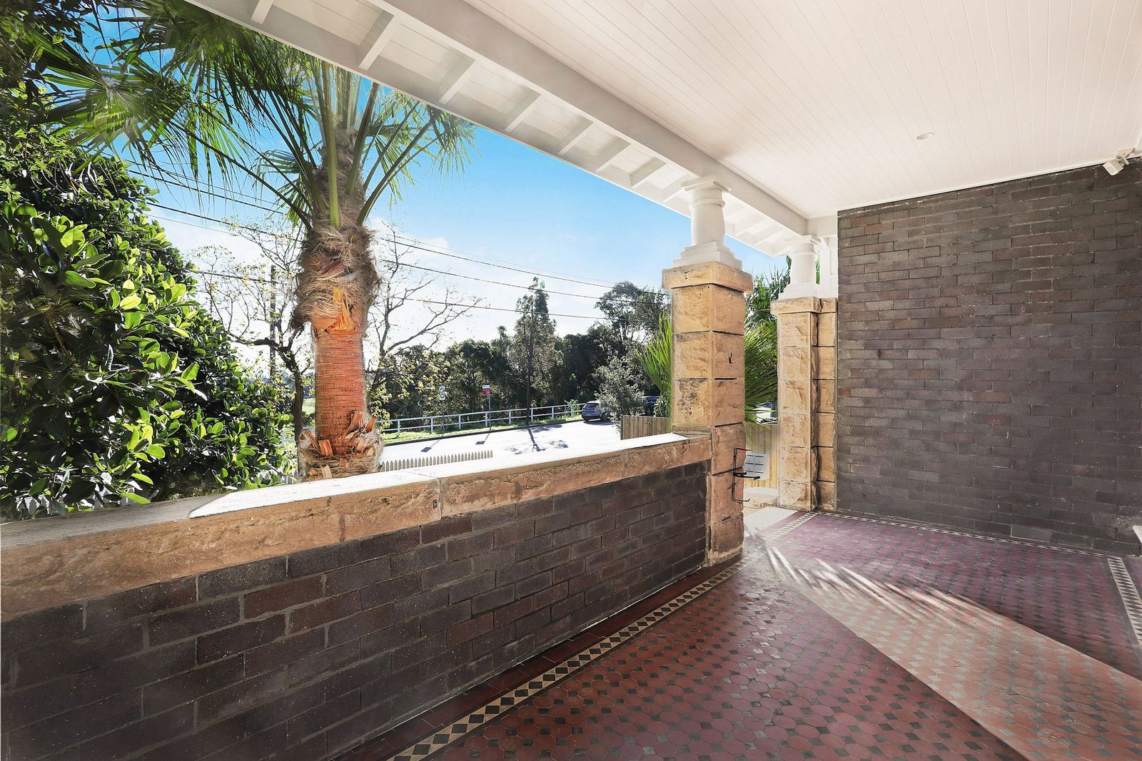 Queens Park Apartments, covered terrace with brick wall and palm tree, built by HP Constructions with Ignite Architects