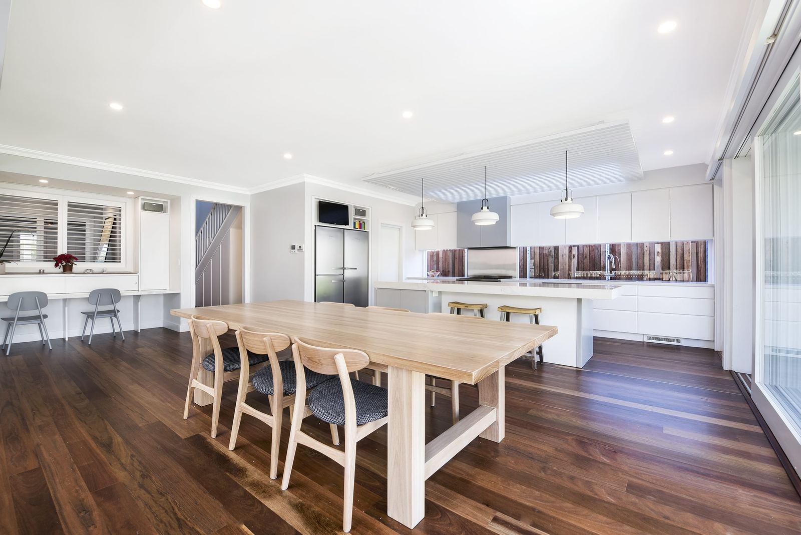 Seaforth, timber dining table beside the open kitchen with pendant lighting, built by HP Constructions with Playoust Churcher