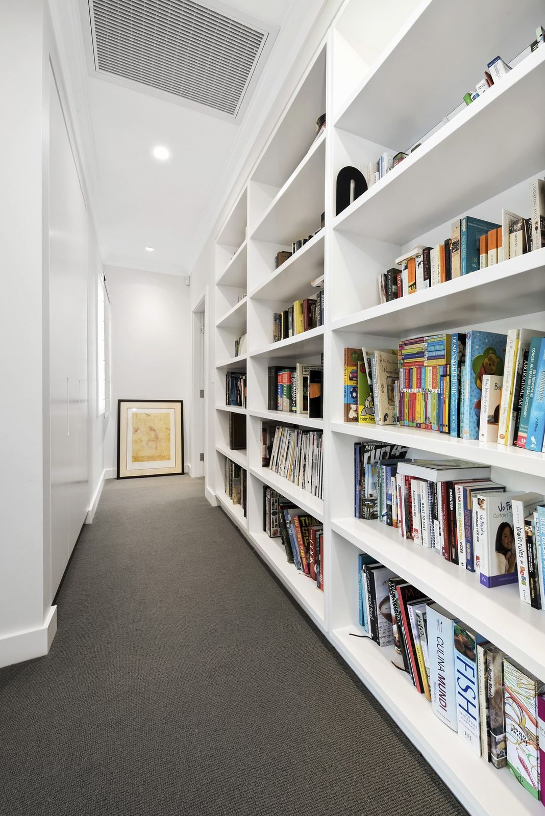 Seaforth, hallway lined with custom timber bookshelves and grey carpet, built by HP Constructions with Playoust Churcher