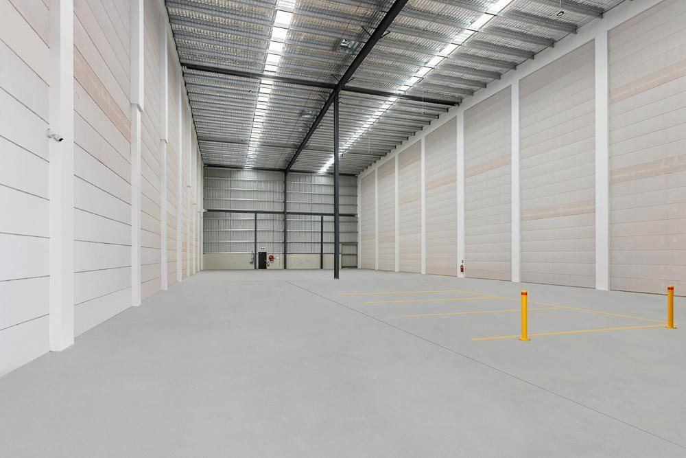 Thornleigh Warehouse, empty high-clearance warehouse interior with skylit roof and yellow bollards, built by HP Constructions