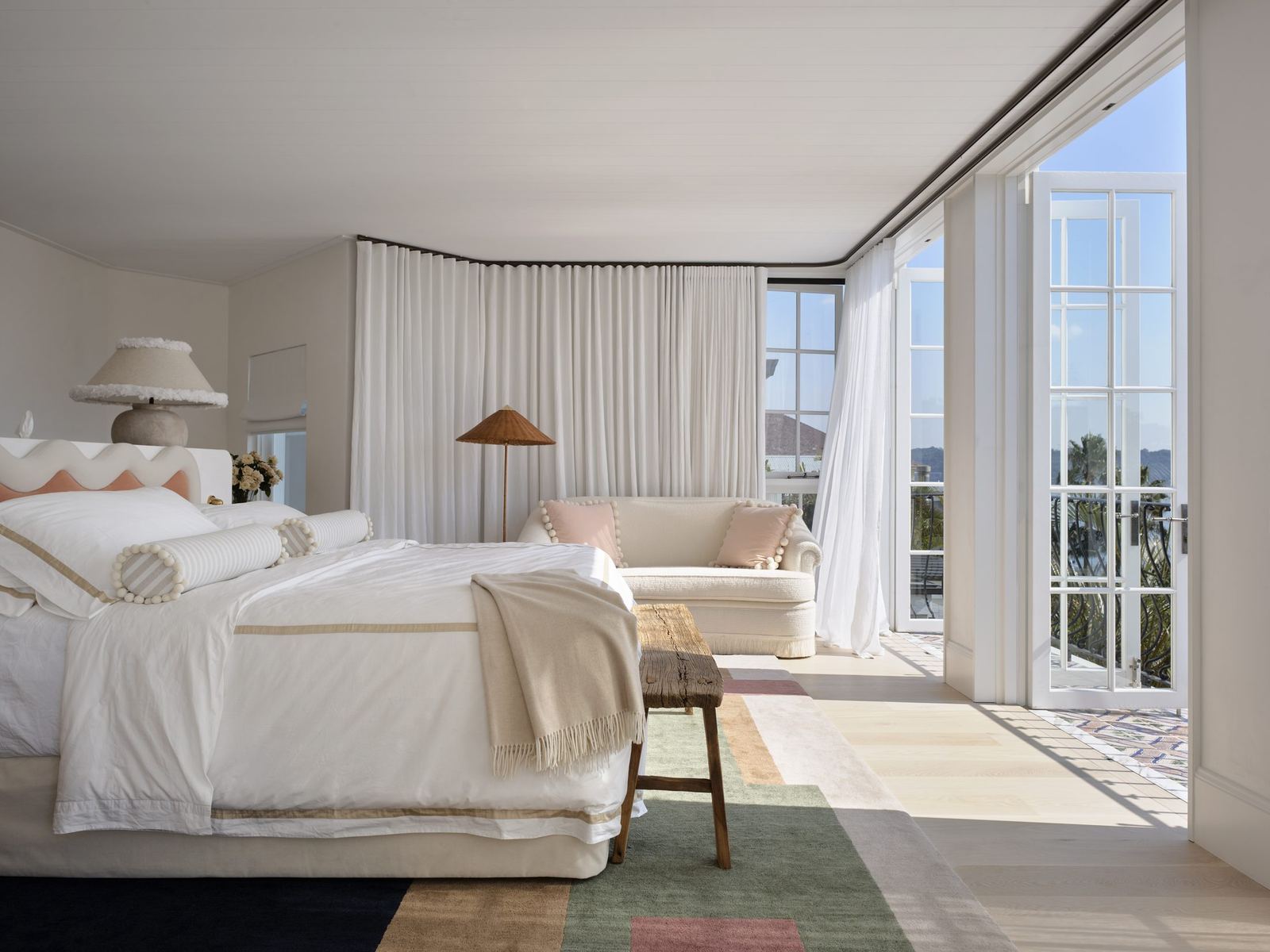 Vaucluse, bedroom with upholstered bed and curtained doors opening to water views, built by HP Constructions with Alexander & Co