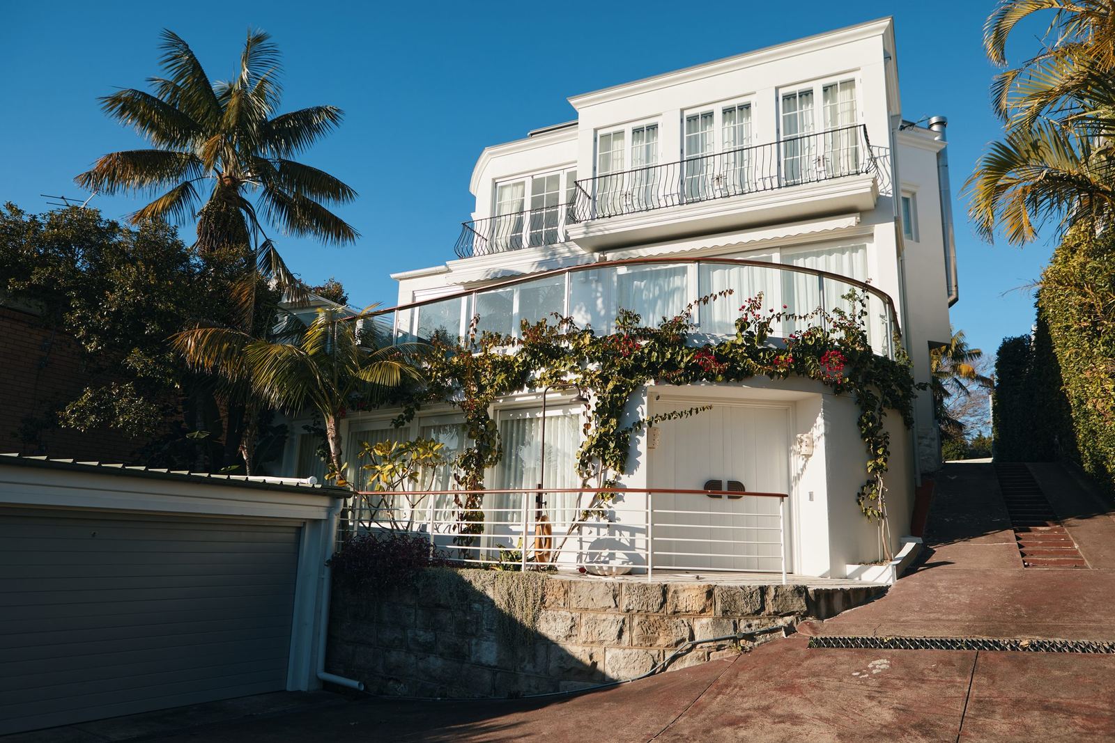 Vaucluse, white multi-storey residence exterior with balconies and palm trees, built by HP Constructions with Alexander & Co