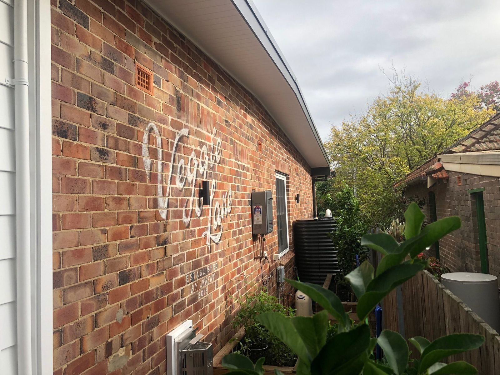 Willoughby, heritage brick exterior wall with signage and garden, built by HP Constructions with Alexander & Co